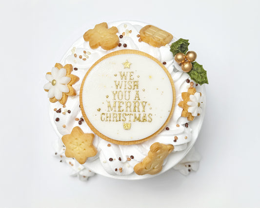 Top view of light, fluffy chiffon layered with soft cream, finished with a wreath of delicate cream swirls, handmade Christmas cookies, and a joyful holiday topper