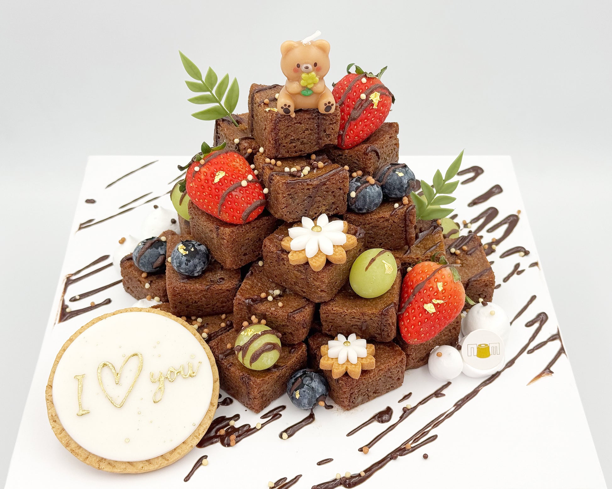 Brownie stacked cake with decorative elements on a white background