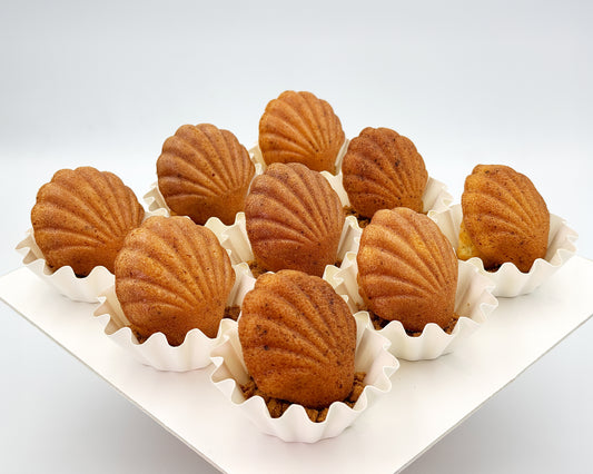 Shell-shaped madeleines on a white tray with a white background