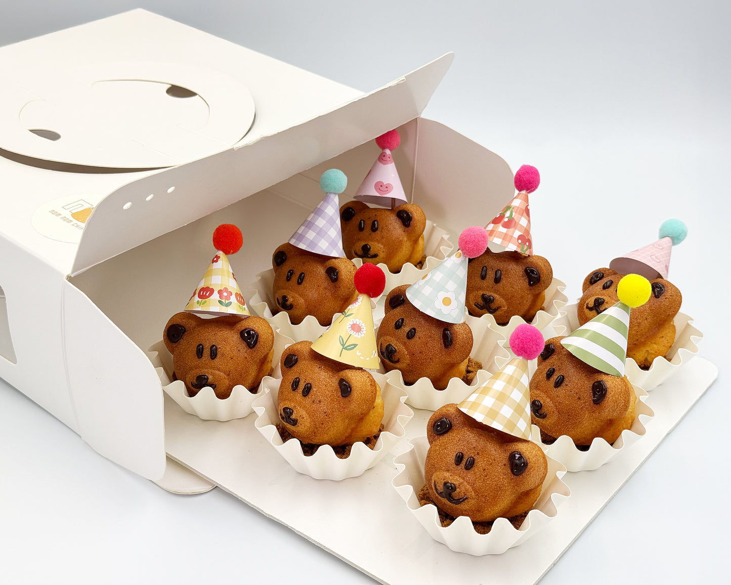 Bear-shaped madeleines with colorful party hats in a box