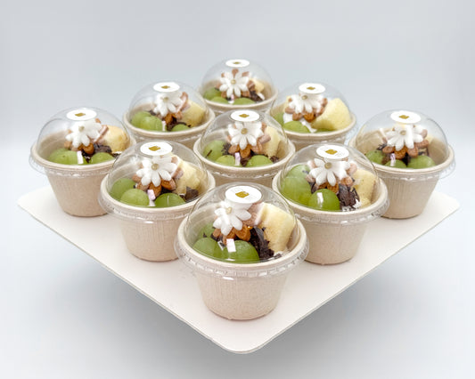 Petite chiffon cups in paper cups with clear domes on a white tray