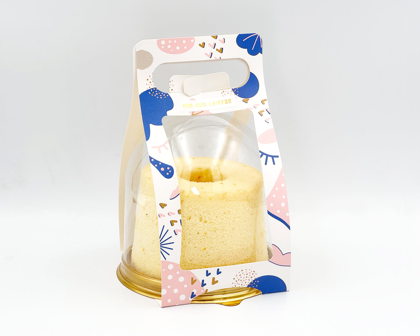 Packaged small chiffon cake with a decorative label on a white background