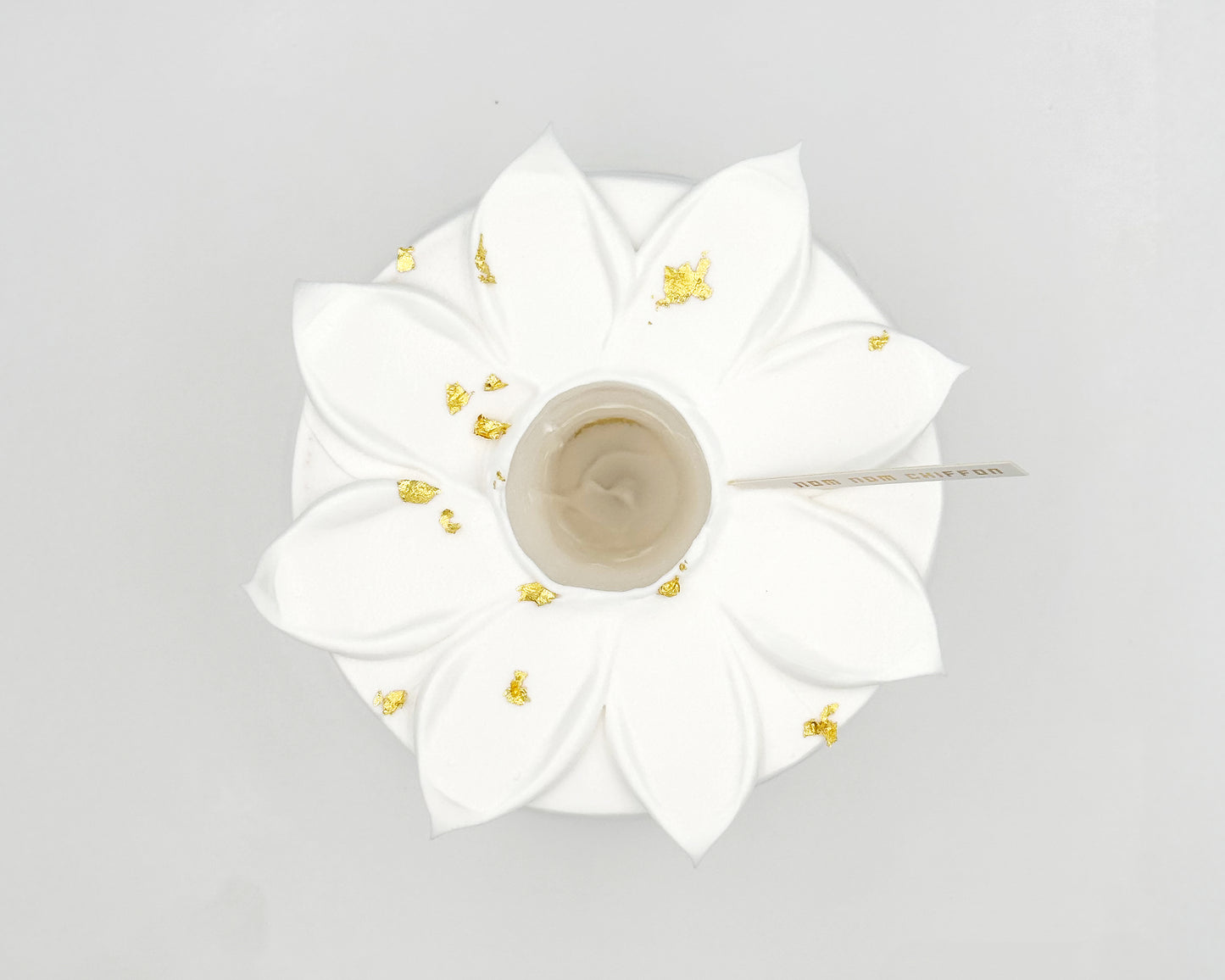 White flower-shaped chiffon cake, top view, on a light gray background