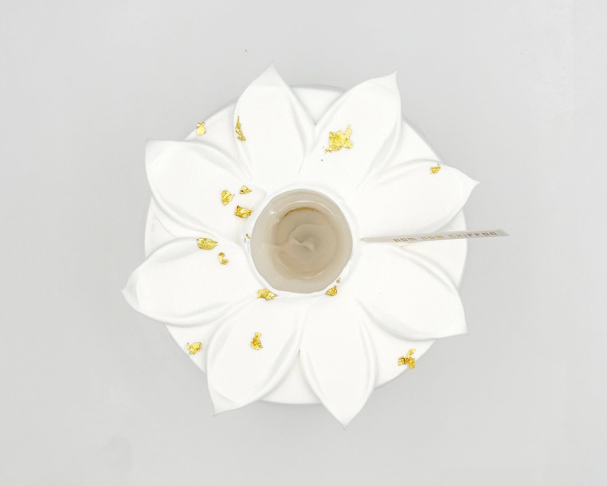 White flower-shaped chiffon cake, top view, on a light gray background