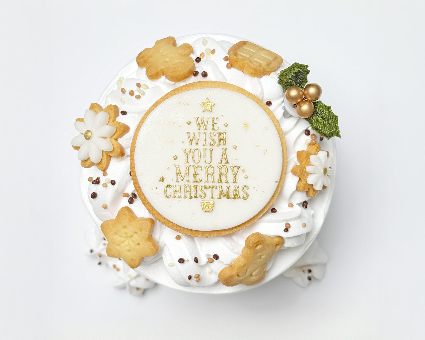 Top view of light, fluffy chiffon layered with soft cream, finished with a wreath of delicate cream swirls, handmade Christmas cookies, and a joyful holiday topper