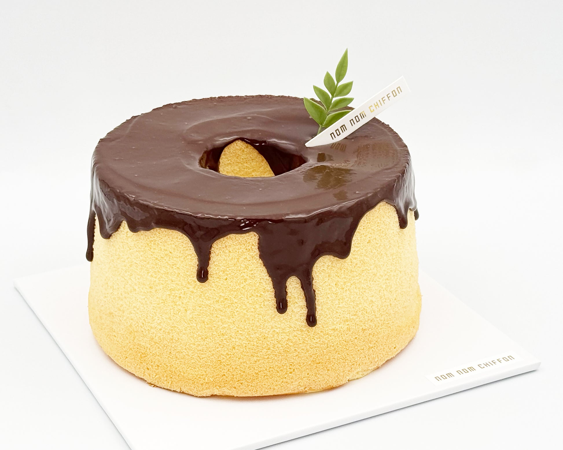 Naked orange zest chiffon cake topped with chocolate ganache, chocolate drip, side view