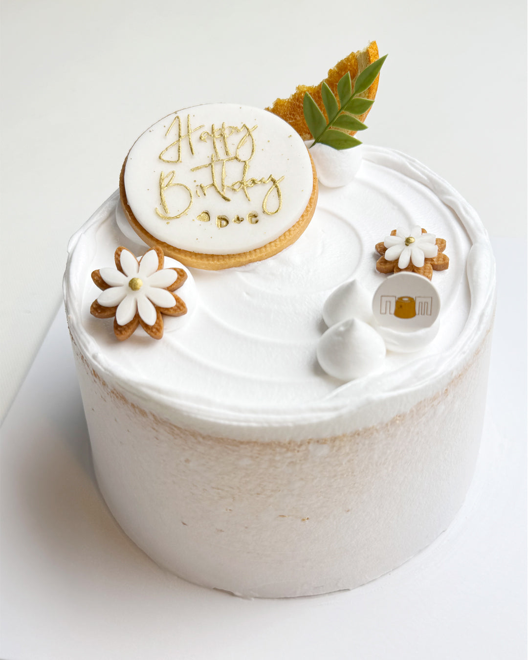 White birthday cake with decorative elements on a white background