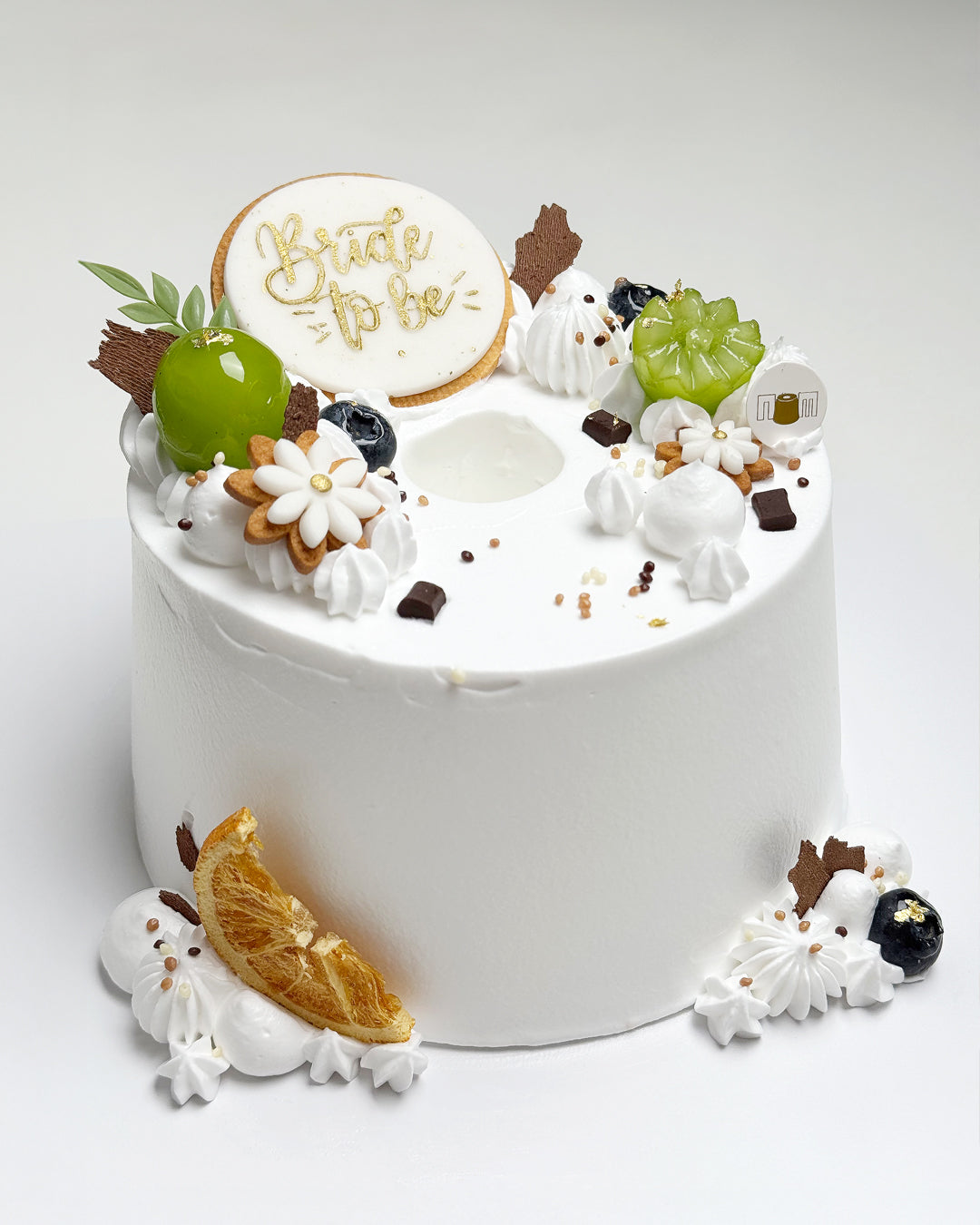 Decorative cake with 'Bride to be' topper on a white background