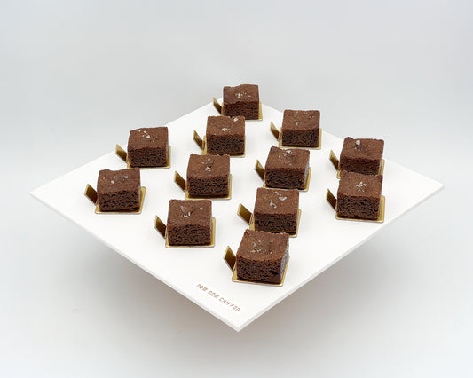Brownie cubes on a white plate with a light background