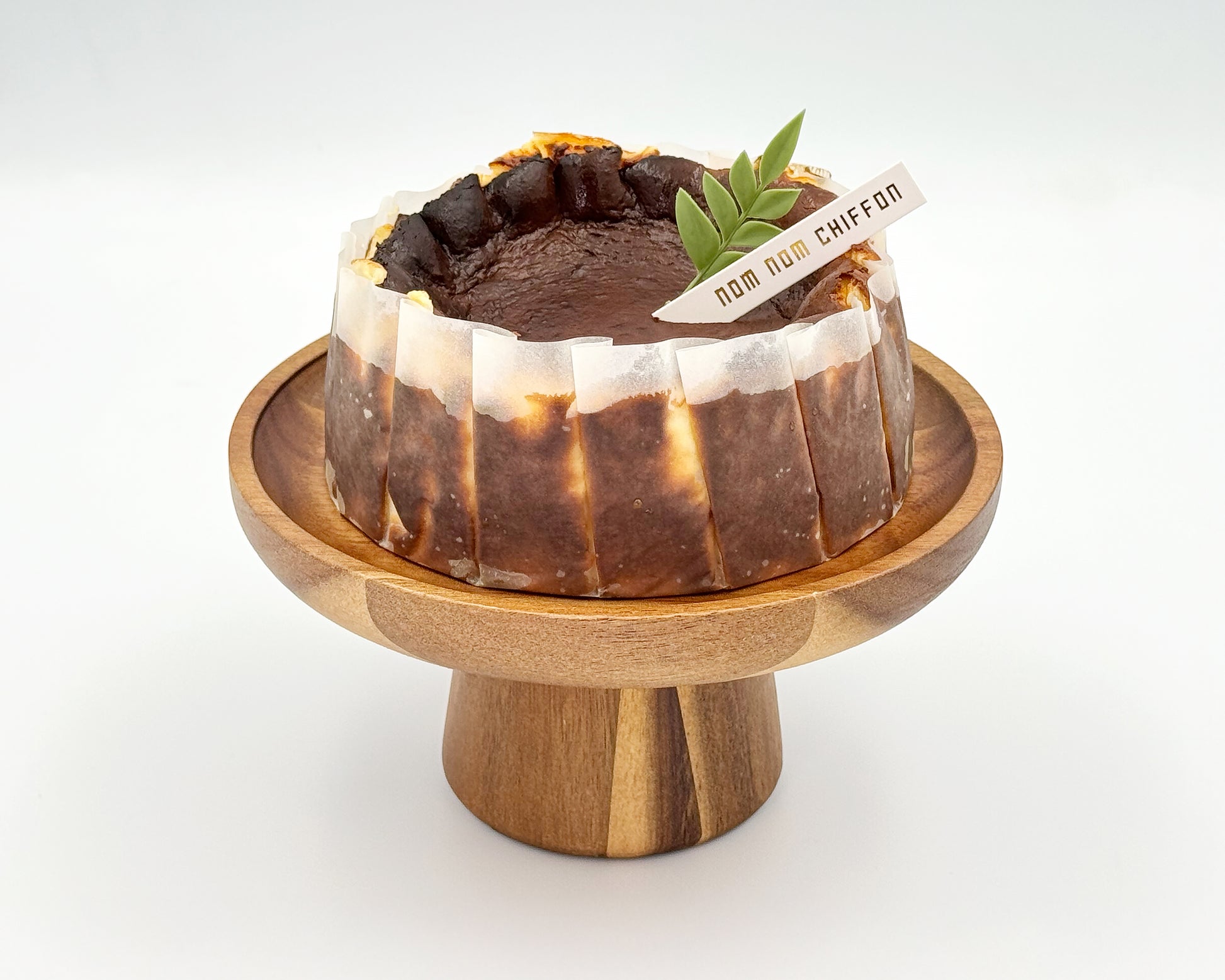 Basque burnt cheesecake on a wooden stand with a white background