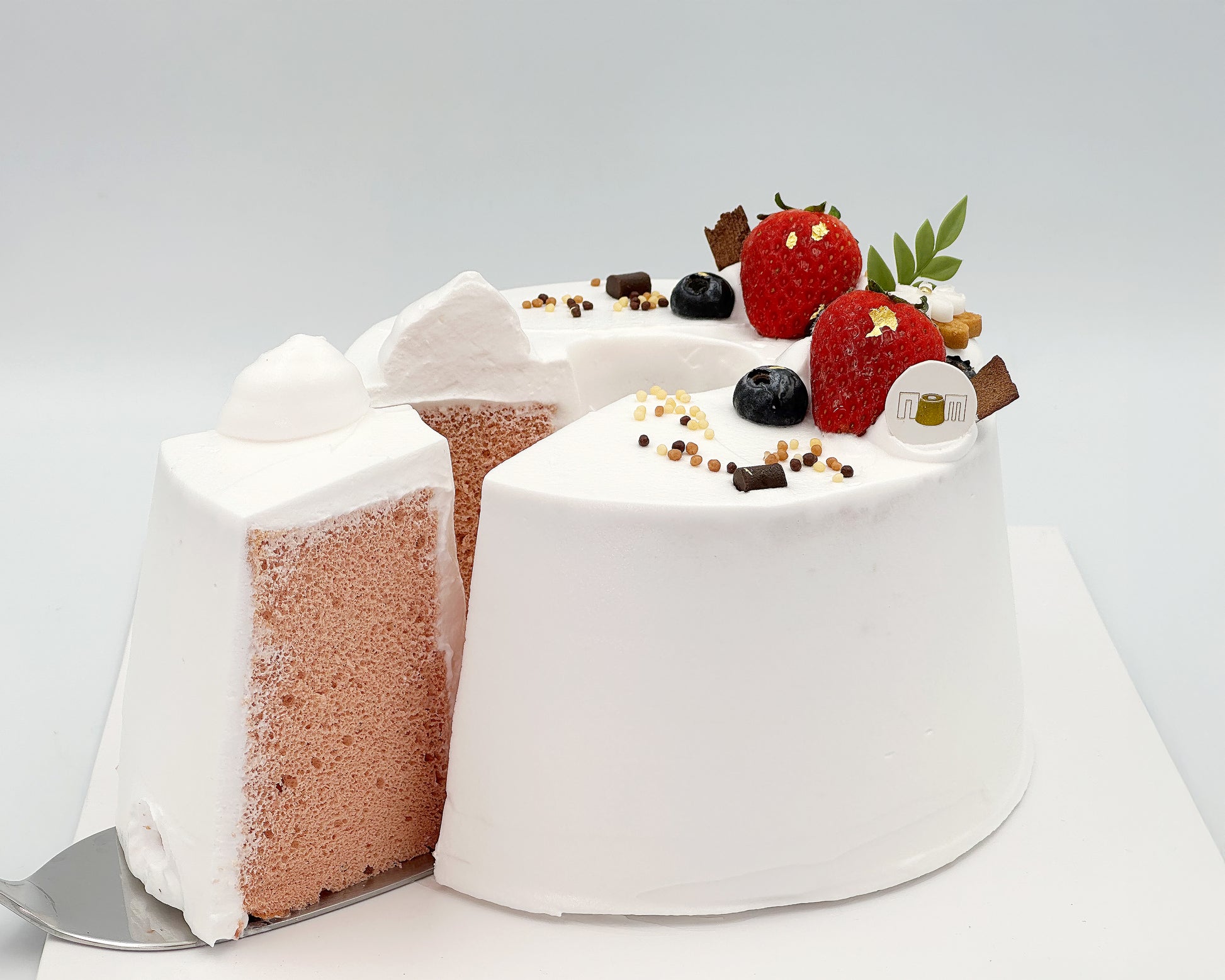 Gender reveal cake with strawberries and chocolate on a white background