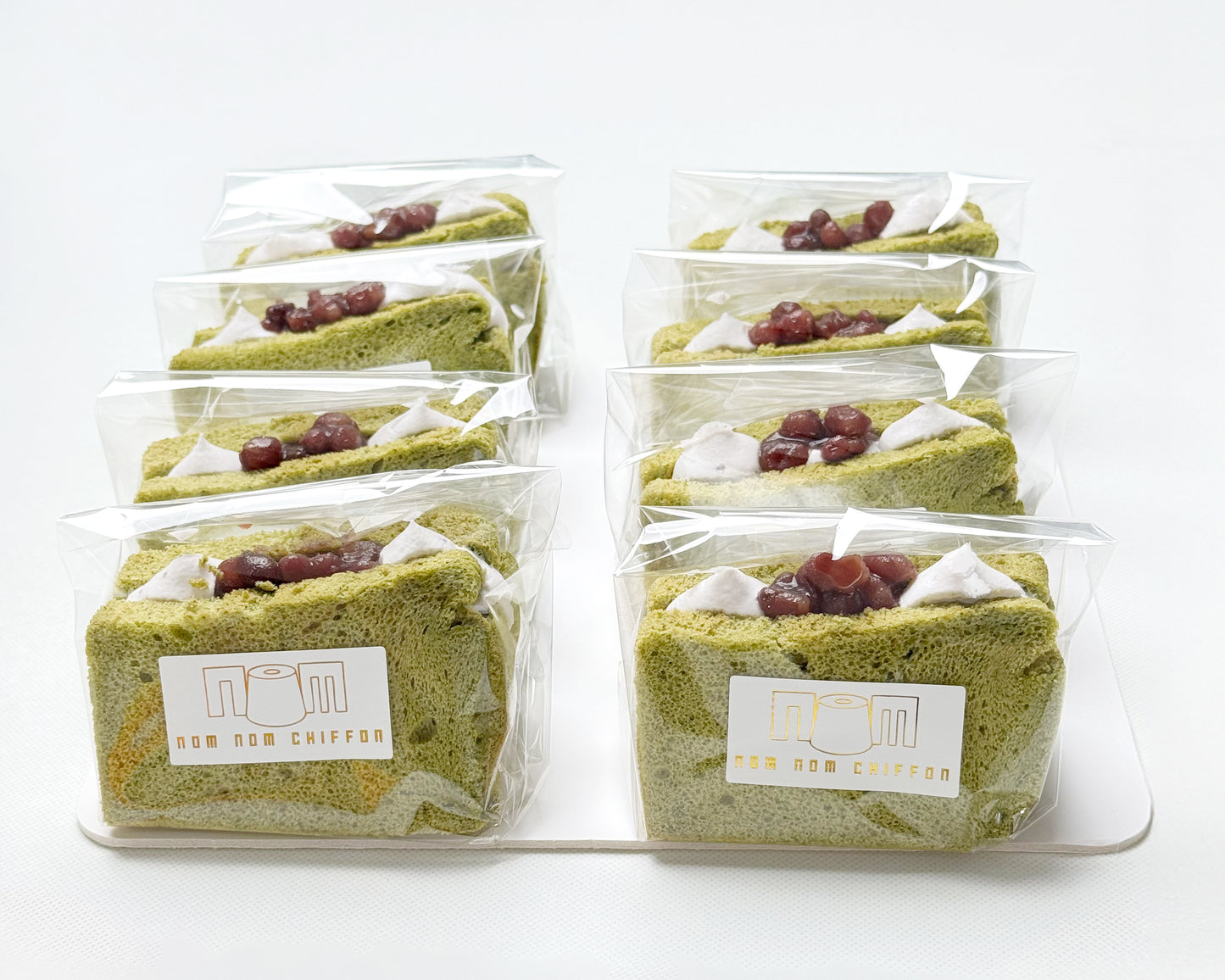 Packaged green tea, matcha chiffon cake slices with Hokkaido Azuki beans and  visible brand logo on a white background