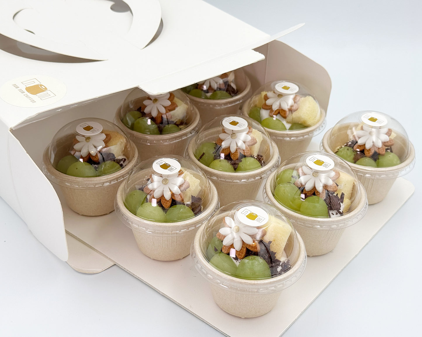 Petite chiffon cups with decorative elements in a packaging box on a white background